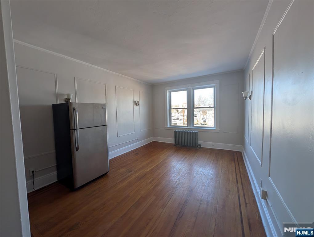 85 Anderson Street, Unit C5 Hackensack, NJ 07601 - Photo 3 of 6 a view of a kitchen with wooden floor refrigerator and window