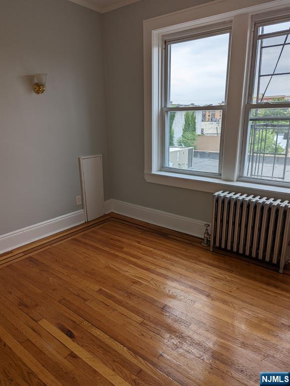 85 Anderson Street, Unit C6 Hackensack, NJ 07601 - Photo 6 of 8 a view of an empty room with wooden floor and a window