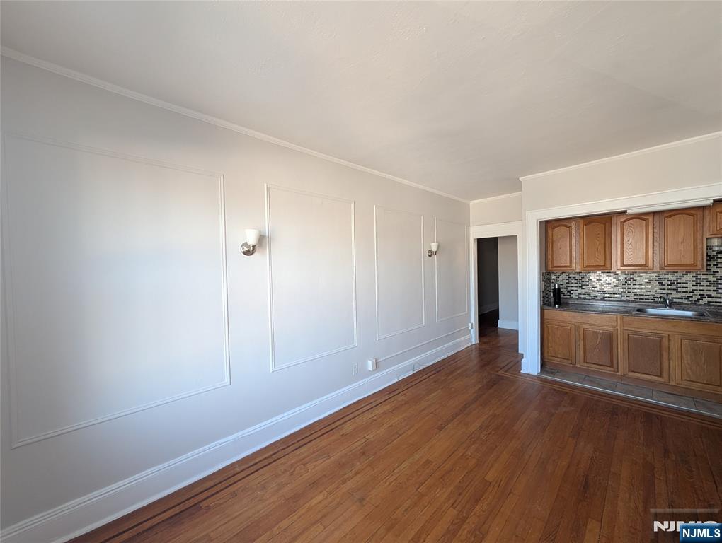 85 Anderson Street, Unit C5 Hackensack, NJ 07601 - Photo 6 of 6 a view of an empty room and kitchen with wooden floor