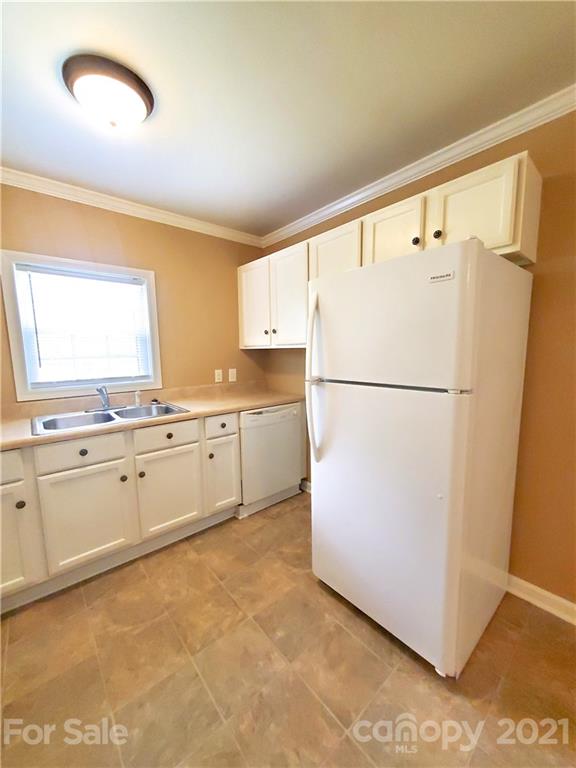 602 Self Street Cherryville, NC 28021 - Photo 14 of 22 a kitchen with granite countertop a refrigerator a sink and white cabinets