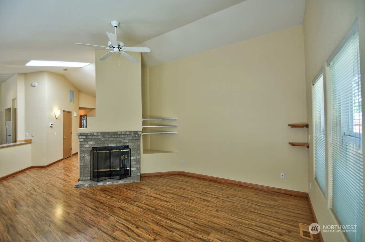 4530 Beckonridge Loop Southeast Lacey, WA 98513 - Photo 7 of 28 an empty room with wooden floor and fireplace