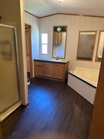 a view of front door and bedroom with wooden floor