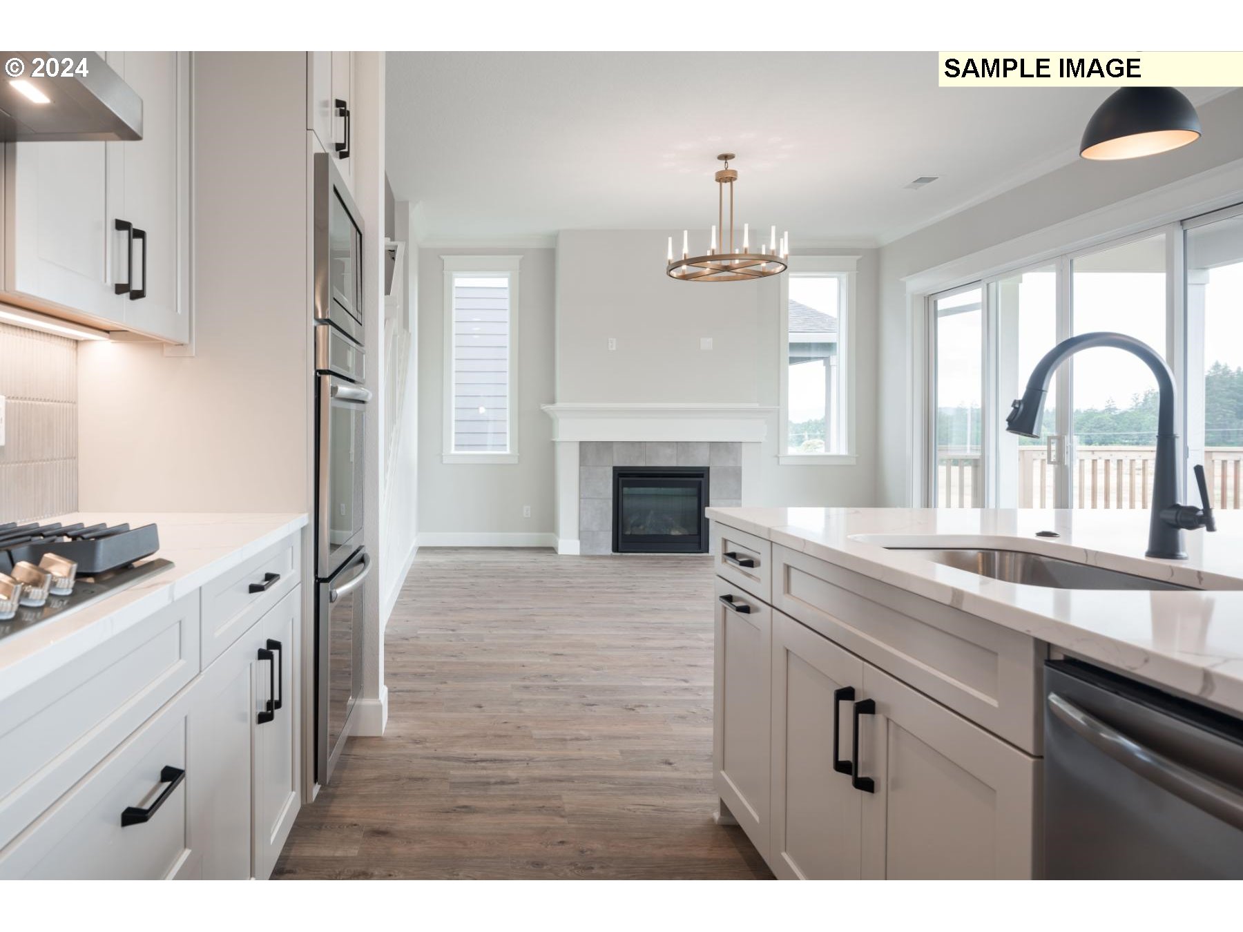 1127 South 46th Place Ridgefield, WA 98642 - Photo 6 of 26 a kitchen with granite countertop a stove a sink and a refrigerator with wooden floor