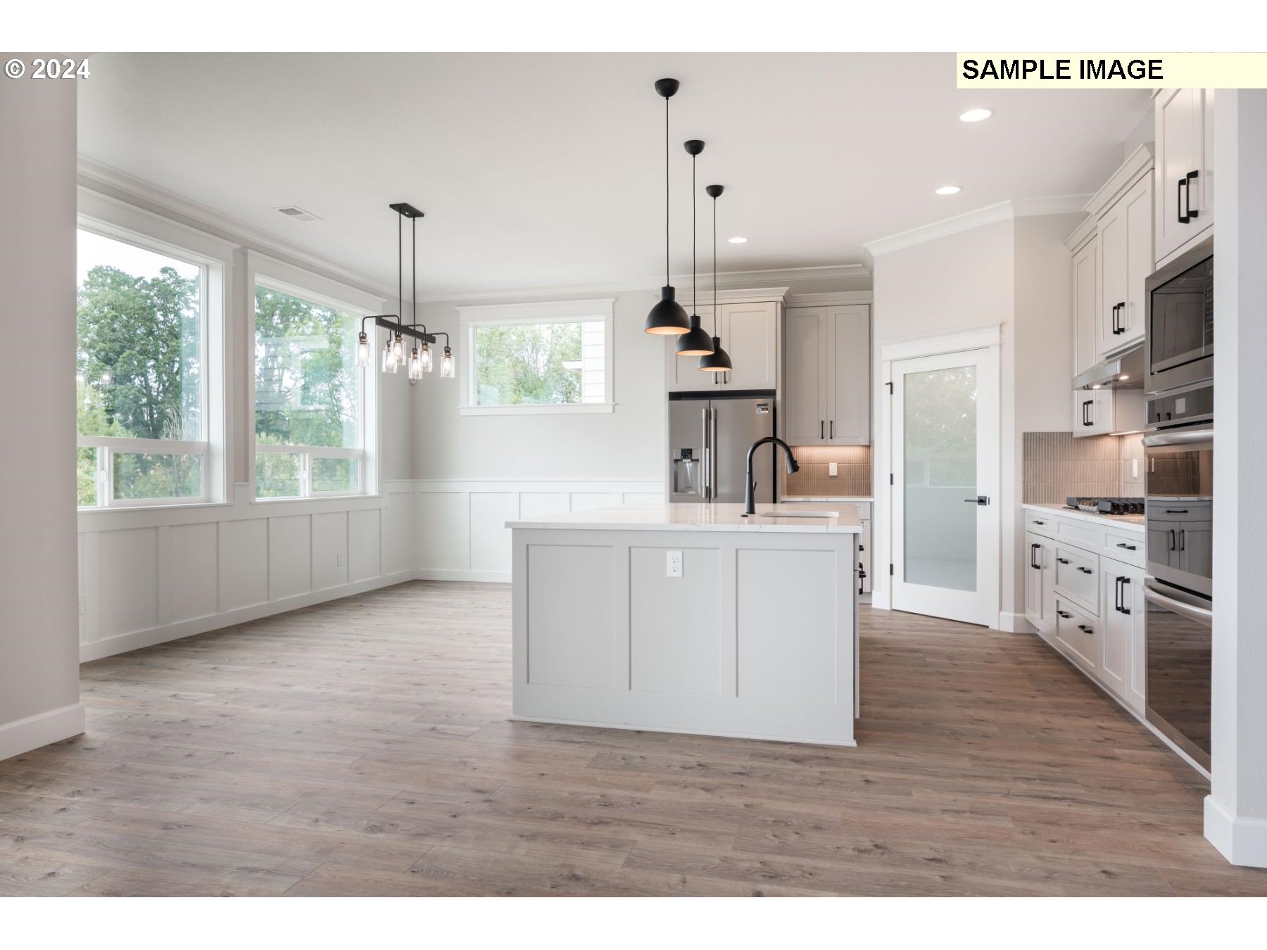1127 South 46th Place Ridgefield, WA 98642 - Photo 10 of 26 a kitchen with stainless steel appliances granite countertop a sink a stove a refrigerator and white cabinets with wooden floor