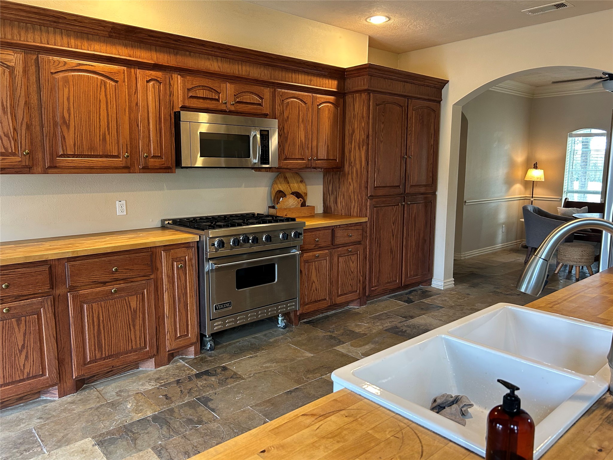 329 Flash Circle Luling, TX 78648 - Photo 10 of 32 Rich wood cabinetry and stone tile flooring define this warm, functional kitchen workspace.