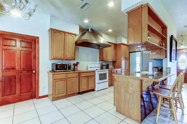 a kitchen with stainless steel appliances granite countertop a sink a stove and cabinets
