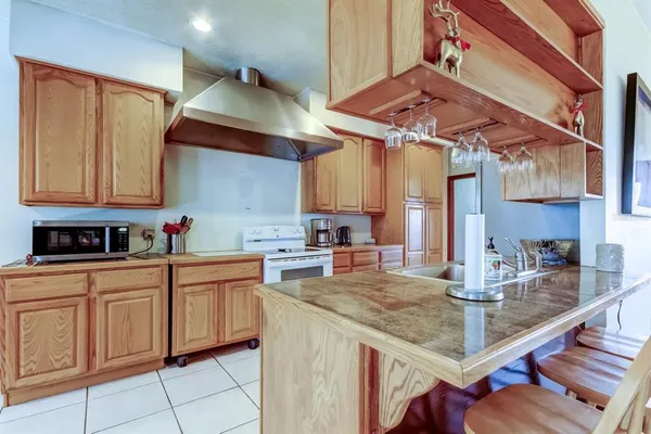 a kitchen with stainless steel appliances granite countertop a sink a stove and refrigerator