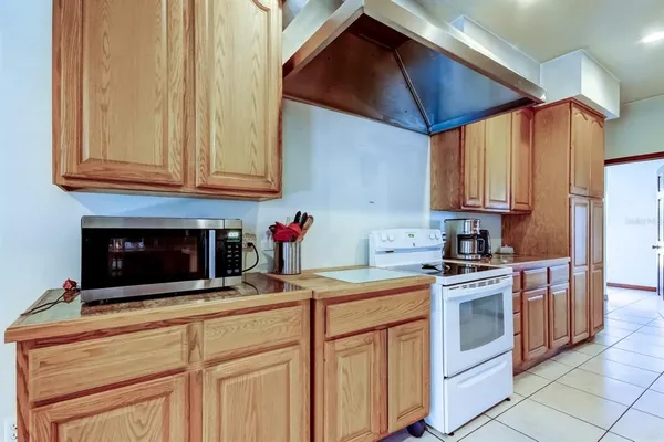 a kitchen with stainless steel appliances granite countertop a refrigerator a stove and a sink with wooden floors