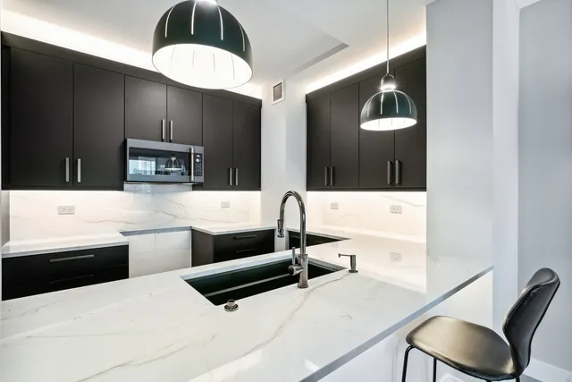 a kitchen with stainless steel appliances kitchen island a sink dishwasher a stove and a microwave oven