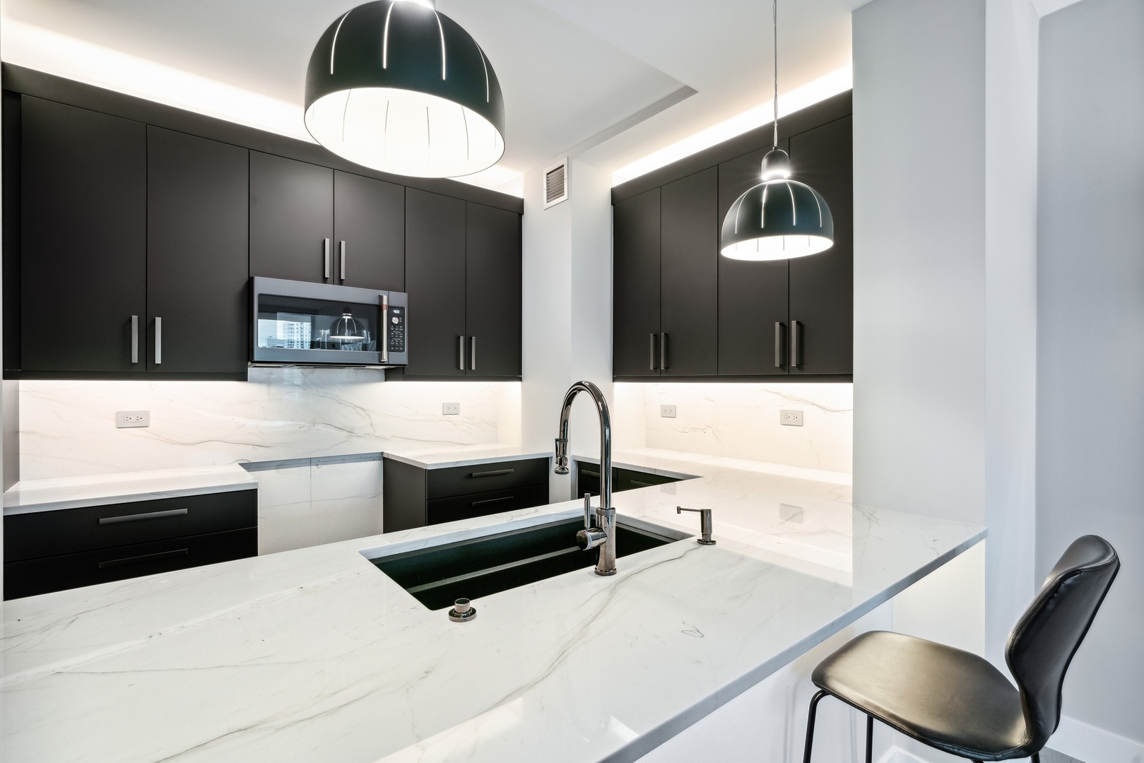 501 North Clinton Street, Unit 2004 Chicago, IL 60654 - Photo 12 of 34 a kitchen with stainless steel appliances kitchen island a sink dishwasher a stove and a microwave oven