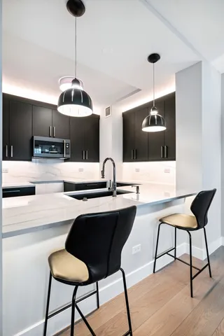 a kitchen with a dining table chairs and white cabinets