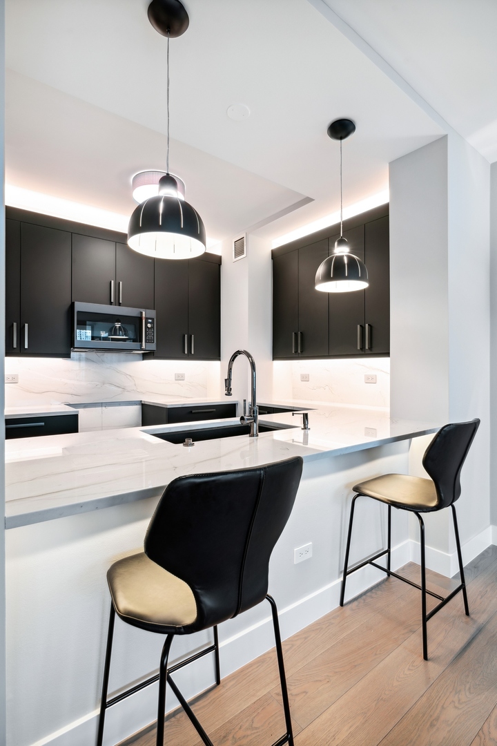 501 North Clinton Street, Unit 2004 Chicago, IL 60654 - Photo 13 of 34 a kitchen with a dining table chairs and white cabinets