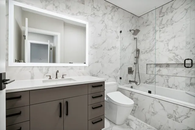 a bathroom with a sink toilet a mirror and shower