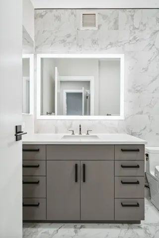 a bathroom with a sink vanity and mirror