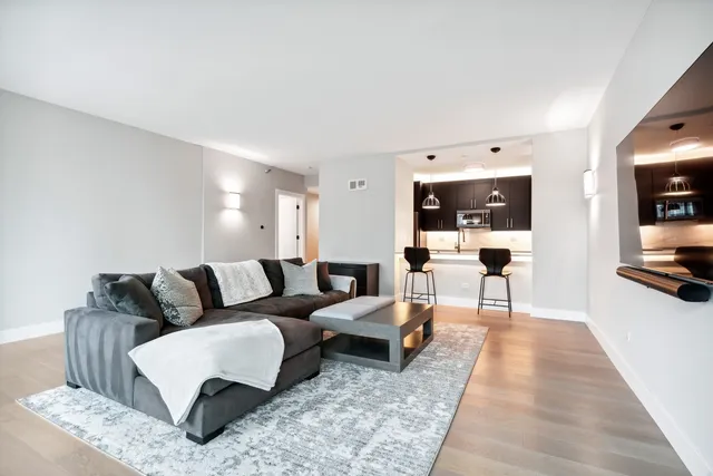 a living room with furniture and view of kitchen