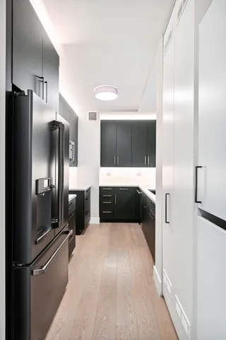 a view of a refrigerator in kitchen and a wooden floor