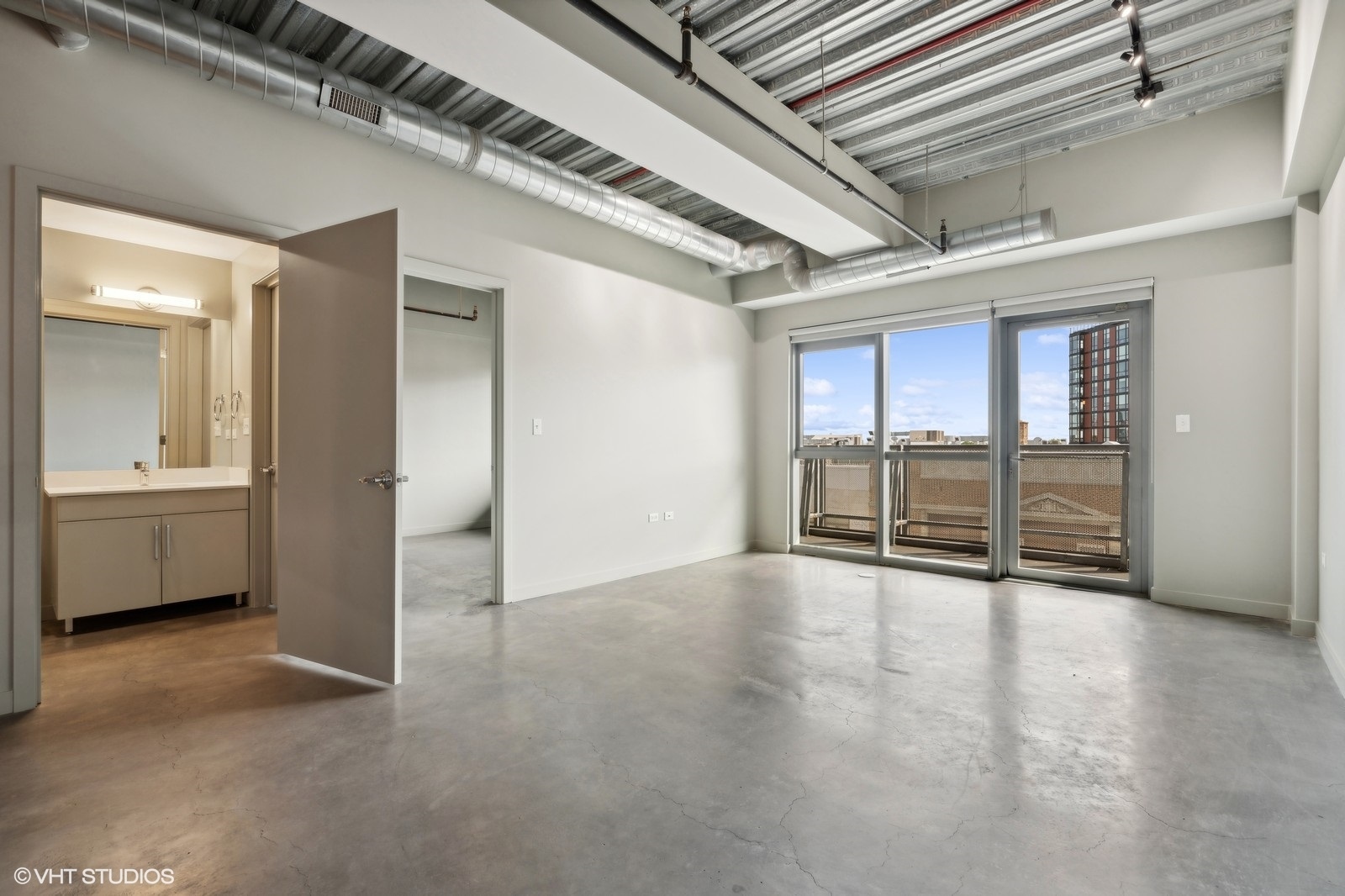 1241 North Milwaukee Avenue, Unit 306 Chicago, IL 60622 - Photo 3 of 14 an empty room with wooden floor and windows