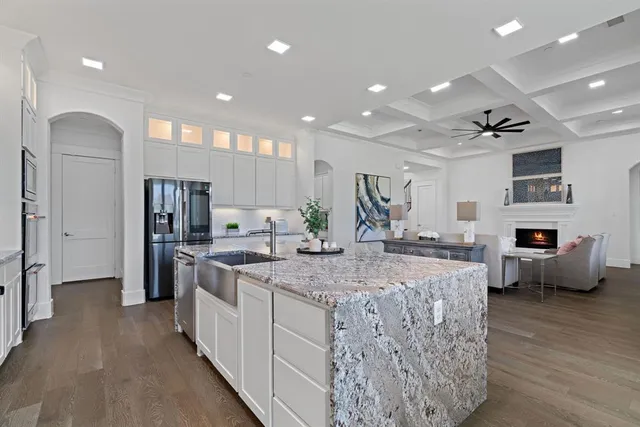 a large kitchen with kitchen island a large counter top space and stainless steel appliances