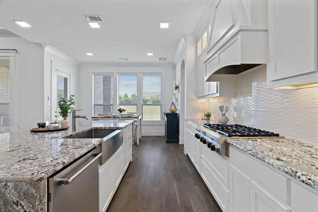 a large kitchen with stainless steel appliances granite countertop a lot of counter space and wooden floor
