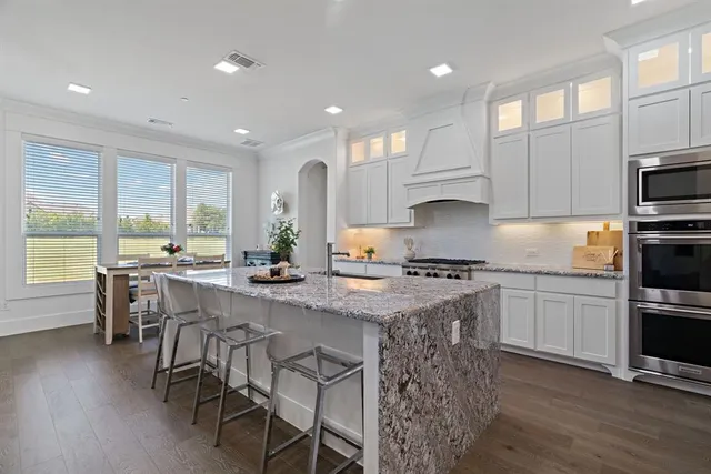 a kitchen with kitchen island granite countertop wooden floors and stainless steel appliances