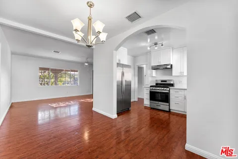 a view of a kitchen with a sink a refrigerator and window