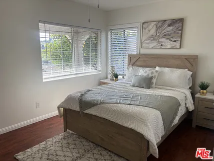 a bedroom with bed and wooden floor