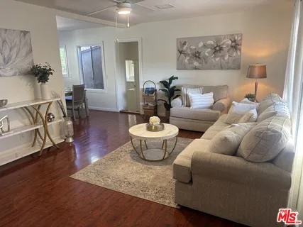 a living room with furniture and a wooden floor