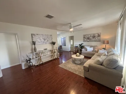 a living room with furniture and a wooden floor