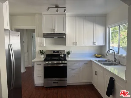 a kitchen with stainless steel appliances granite countertop a stove a refrigerator and a sink