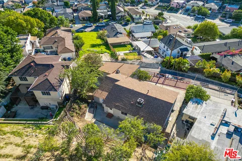 an aerial view of residential houses with outdoor space and swimming pool