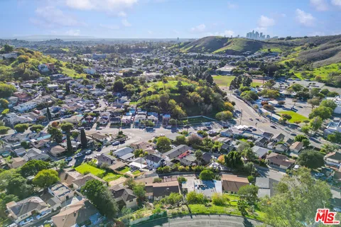 an aerial view of residential houses with outdoor space and parking