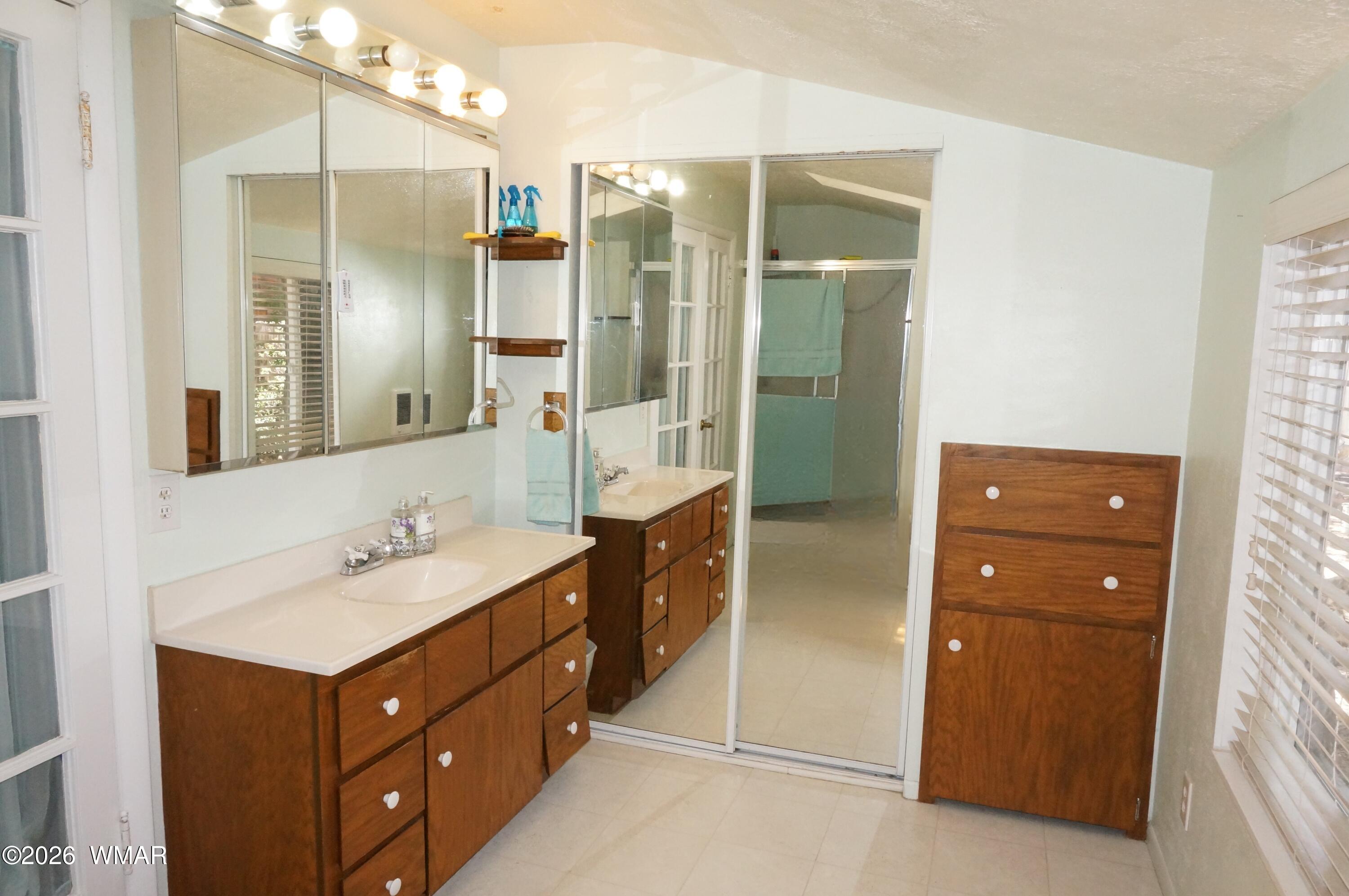 6066 Wagon Wheel Road Lakeside, AZ 85929 - Photo 15 of 32 a bathroom with a double vanity sink and mirror