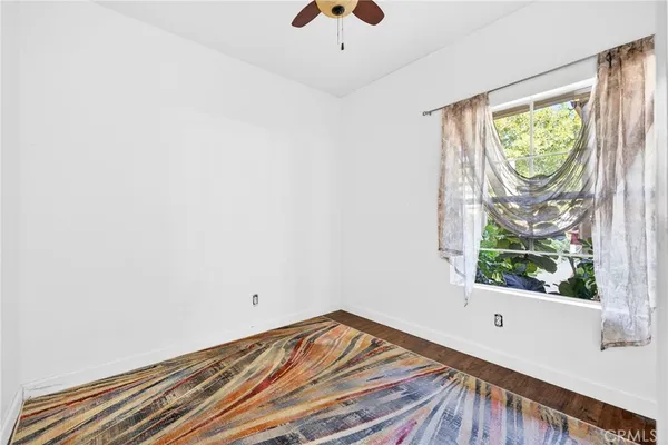 an empty room with a window and a ceiling fan