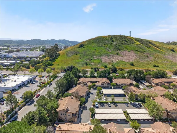 an aerial view of residential houses with outdoor space and trees