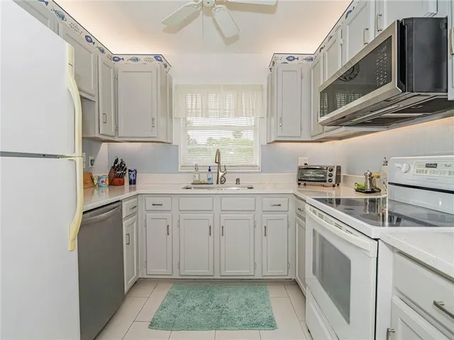 a kitchen with white cabinets sink and white appliances