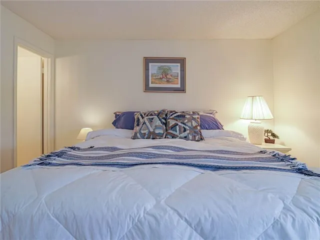 a bedroom with a large bed and a lamp