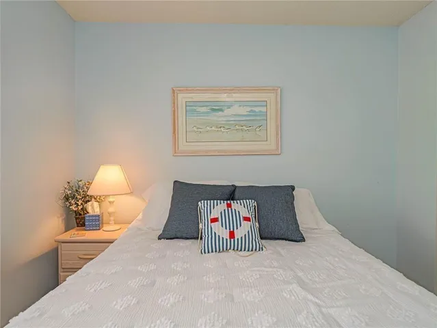 a bedroom with a bed and a painting on the wall