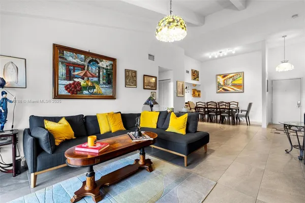 a living room with furniture piano and a chandelier