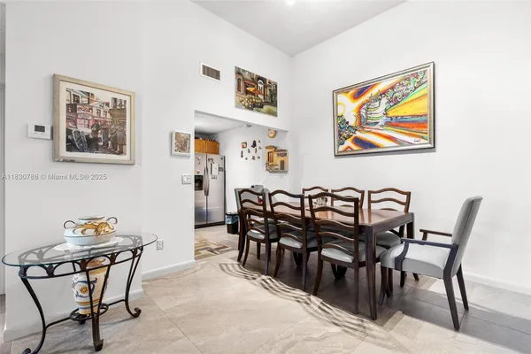 a view of a dining room and livingroom with furniture wooden floor and painting on the wall