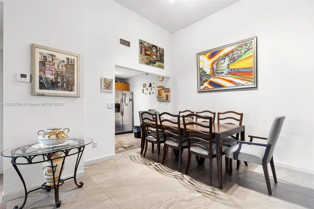 a view of a dining room and livingroom with furniture wooden floor and painting on the wall