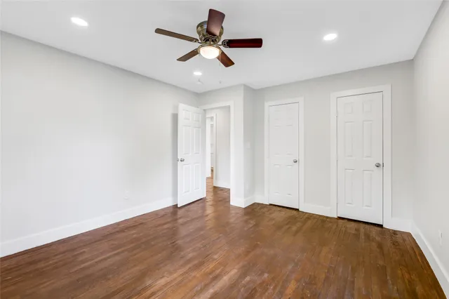 a bedroom with a large bed and a ceiling fan