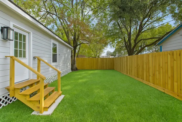 a backyard of a house with table and chairs