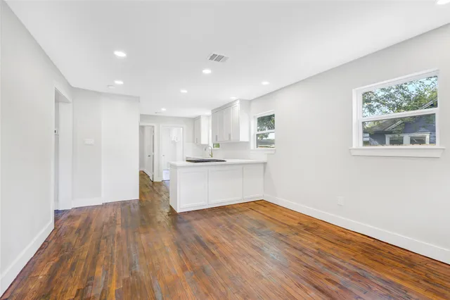 a kitchen with granite countertop white cabinets and a table