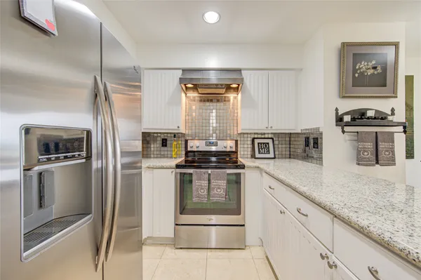 a kitchen with stainless steel appliances granite countertop a stove and a refrigerator