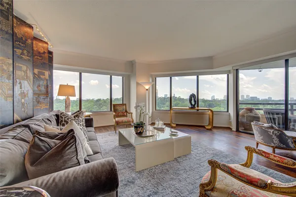 a living room with furniture and floor to ceiling windows