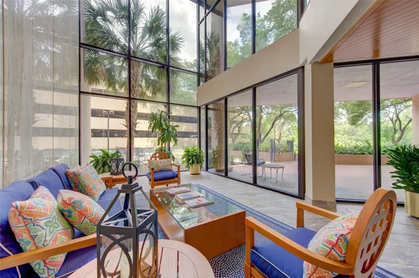 a living room with patio furniture and a floor to ceiling window