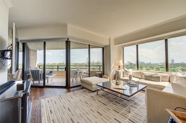 a living room with furniture and floor to ceiling windows