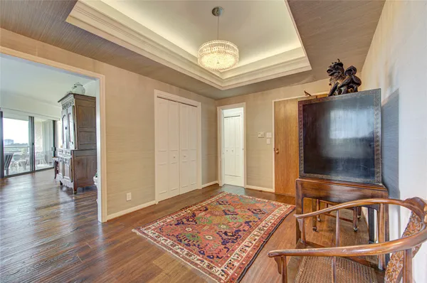 a view of a hallway with wooden floor and a chandelier