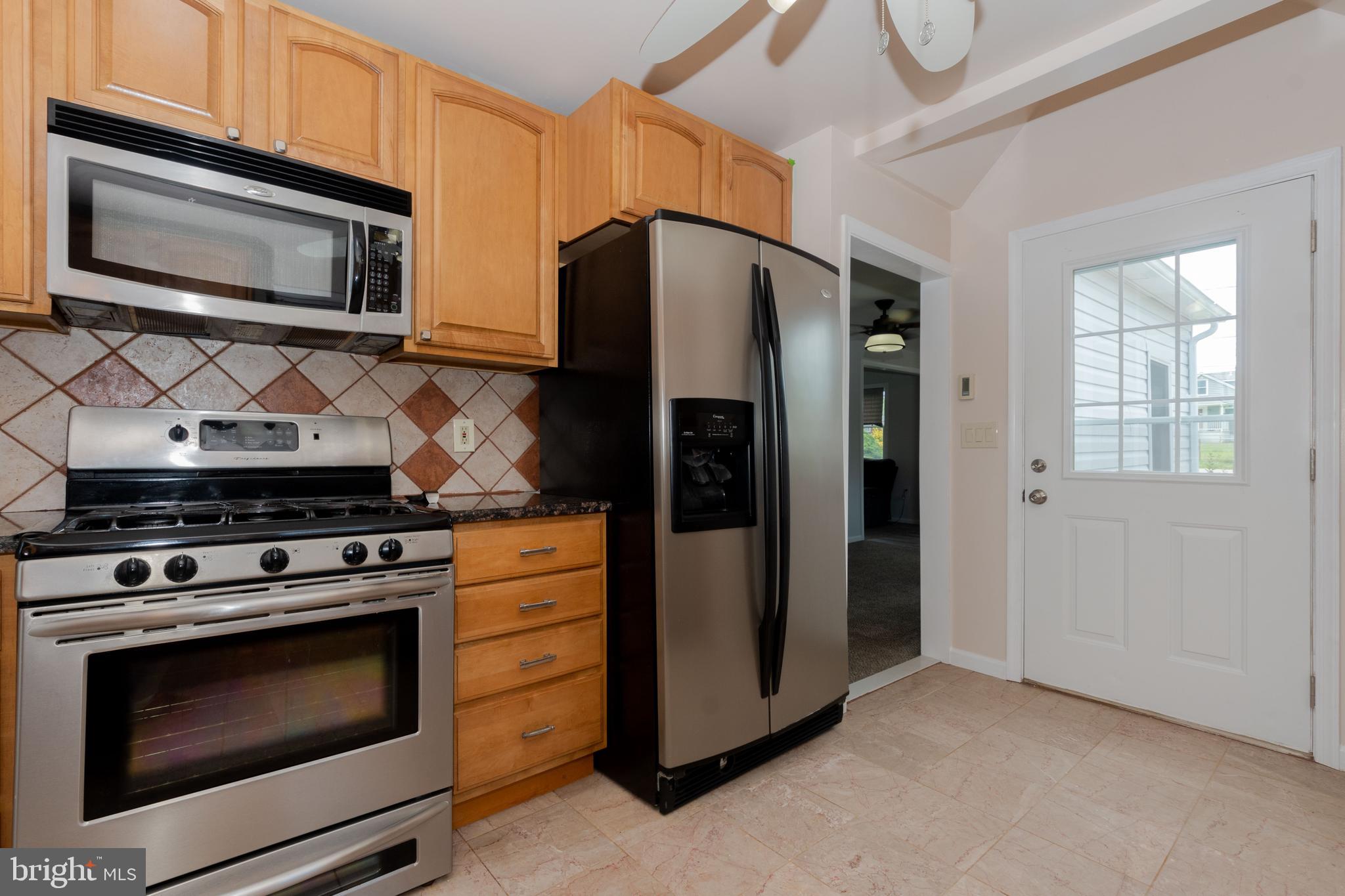 6414 Kenwood Avenue Rosedale, MD 21237 - Photo 15 of 60 a kitchen with stainless steel appliances a stove a microwave and cabinets
