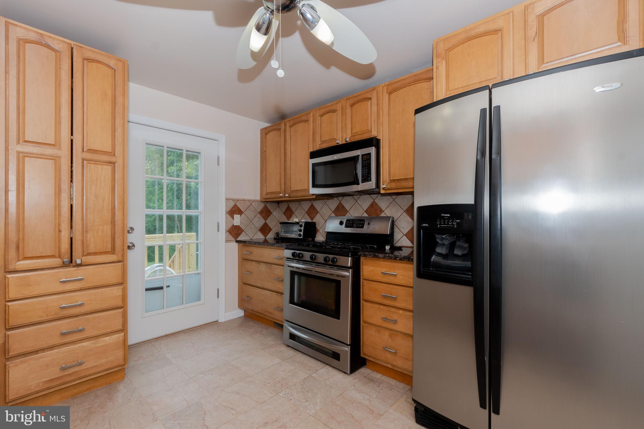 6414 Kenwood Avenue Rosedale, MD 21237 - Photo 17 of 60 a kitchen with stainless steel appliances granite countertop a refrigerator and a stove top oven